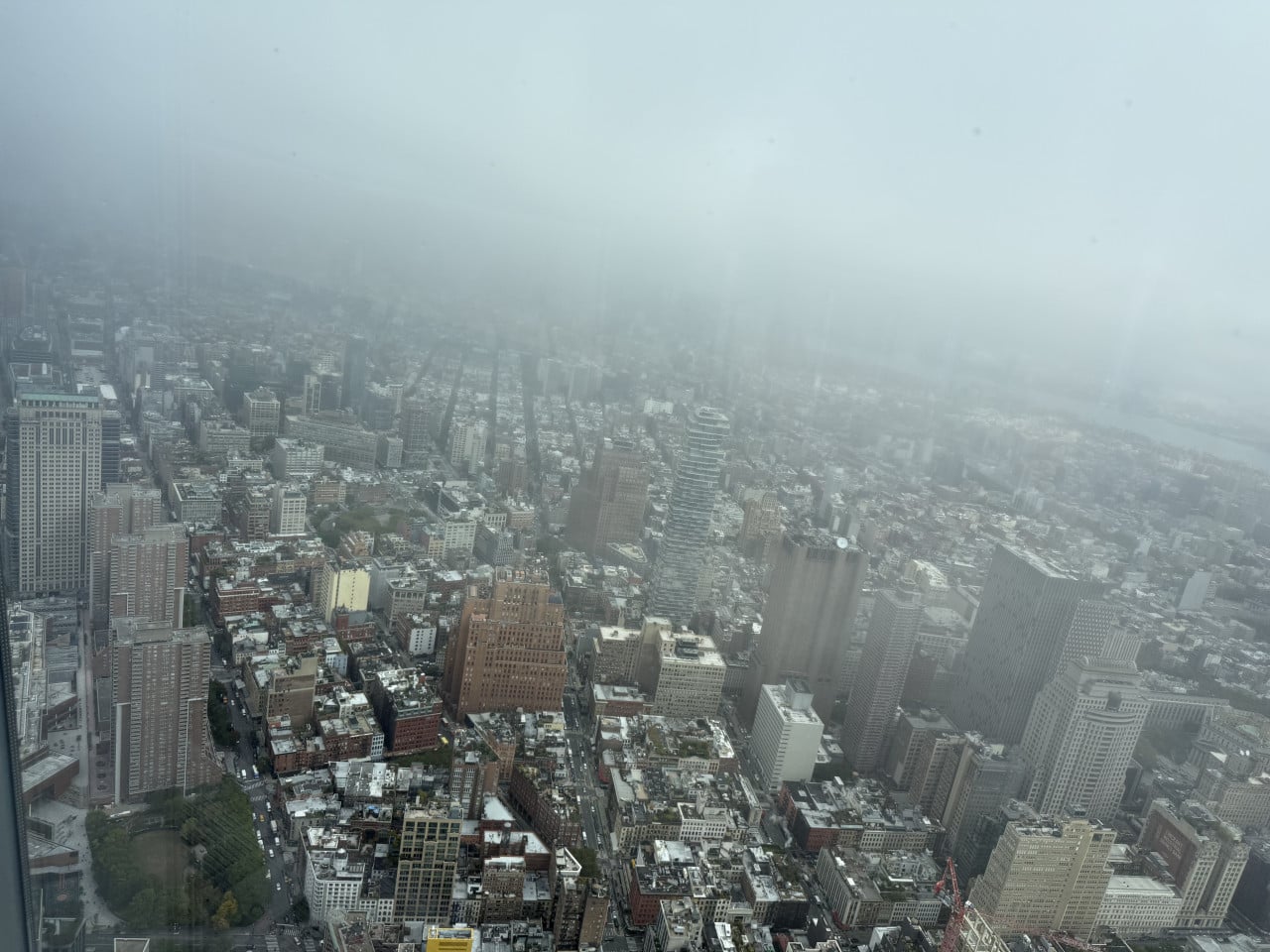 Zamlžený panoramatický výhled na Manhattan z výšky, mrakodrapy a město pod mlhou.