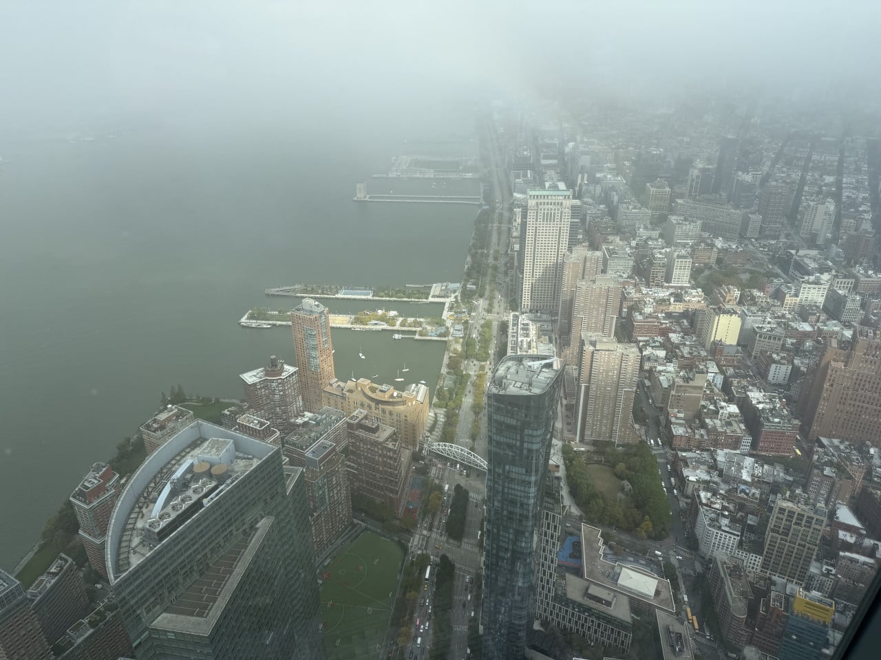Pohled z výšky na Manhattan a řeku Hudson v mlze z One World Center
