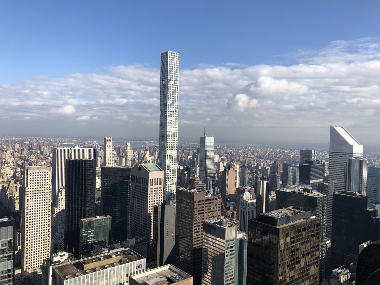 Panorama Manhattanu s One World Center a mrakodrapy pod modrou oblohou.