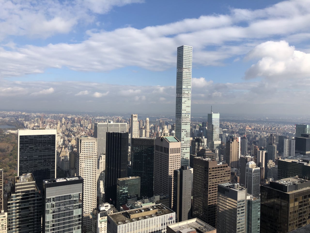 Panorama Manhattanu s věží One World Center pod modrou oblohou.