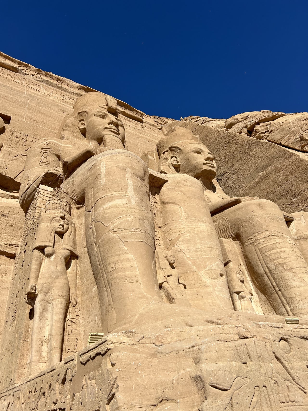 Obří sedící sochy u chrámu Abu Simbel pod modrou oblohou