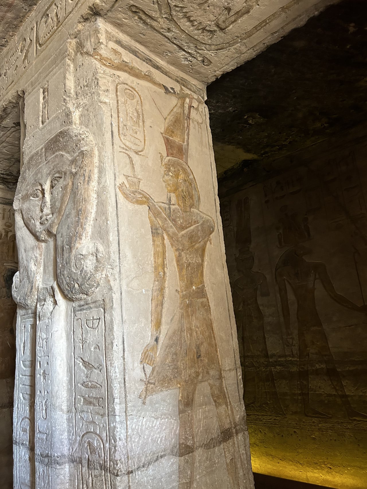 Reliéf egyptského chrámu s vytesaným sloupem a malovanou postavou v Abu Simbelu
