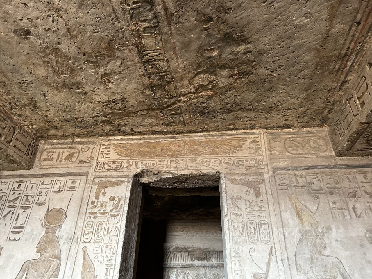 Vnitřek egyptského chrámu s hieroglyfy a nízkým kamenným vstupem
