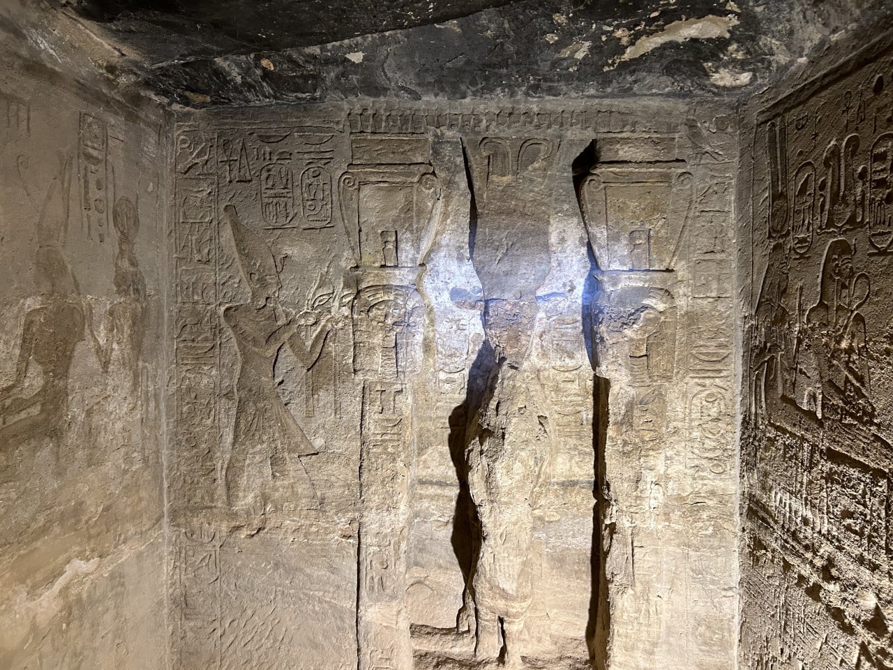 Vytesaná egyptská stěna s reliéfy a hieroglyfy v chrámu Abu Simbel