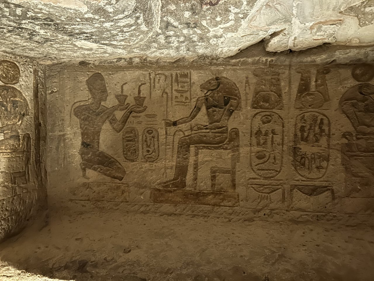 Reliéf v Abu Simbelu s egyptskými postavami a hieroglyfy na skalní stěně
