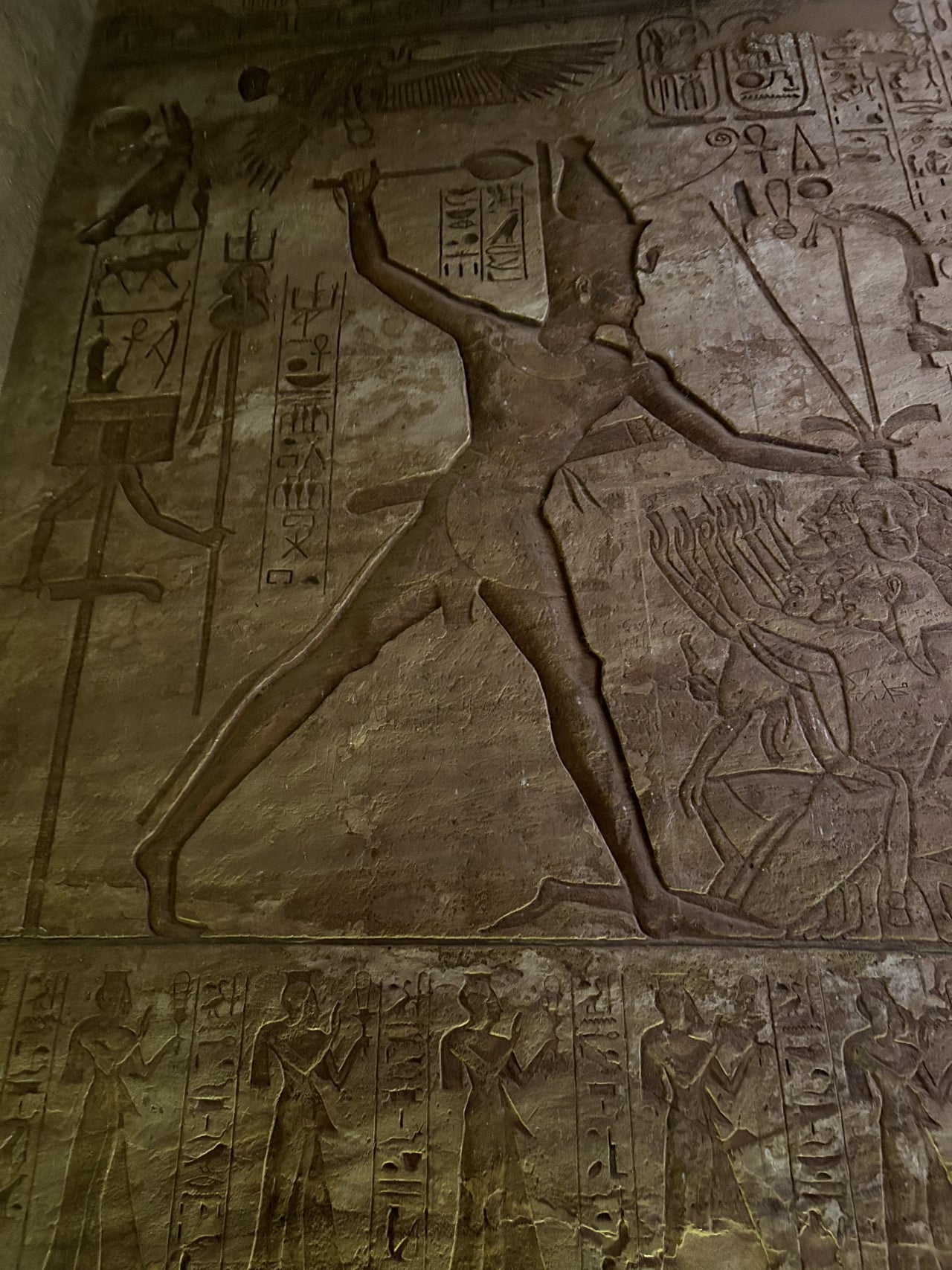 Reliéf s egyptskými hieroglyfy a postavou v chrámu Abu Simbel