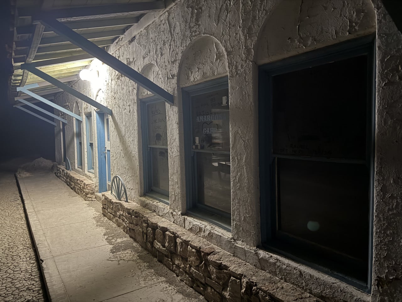 Noční chodba Amargosa Opera House s modrými dveřmi a okny pod lampou