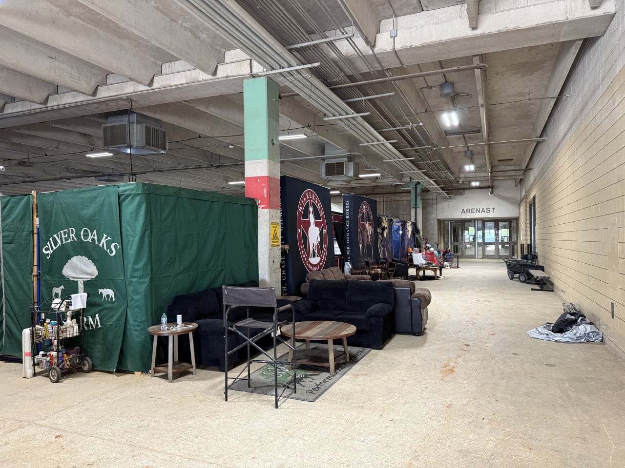 Chodba arény s boxy, sedačkami a nápisem ARENAS v Will Rogers Memorial Center.