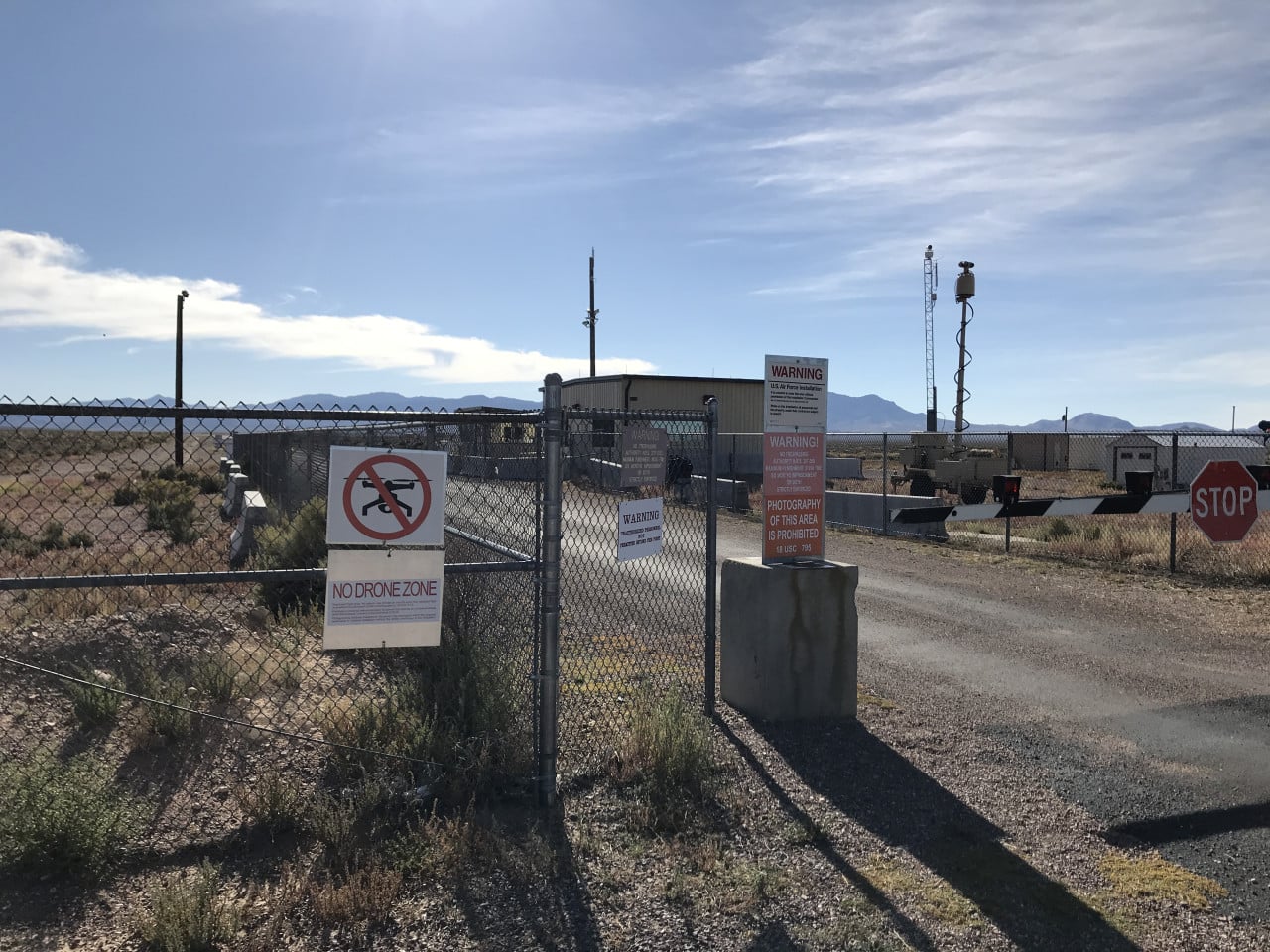 Vstupní brána Area 51 v poušti, oplocení, výstražné cedule a stop značka