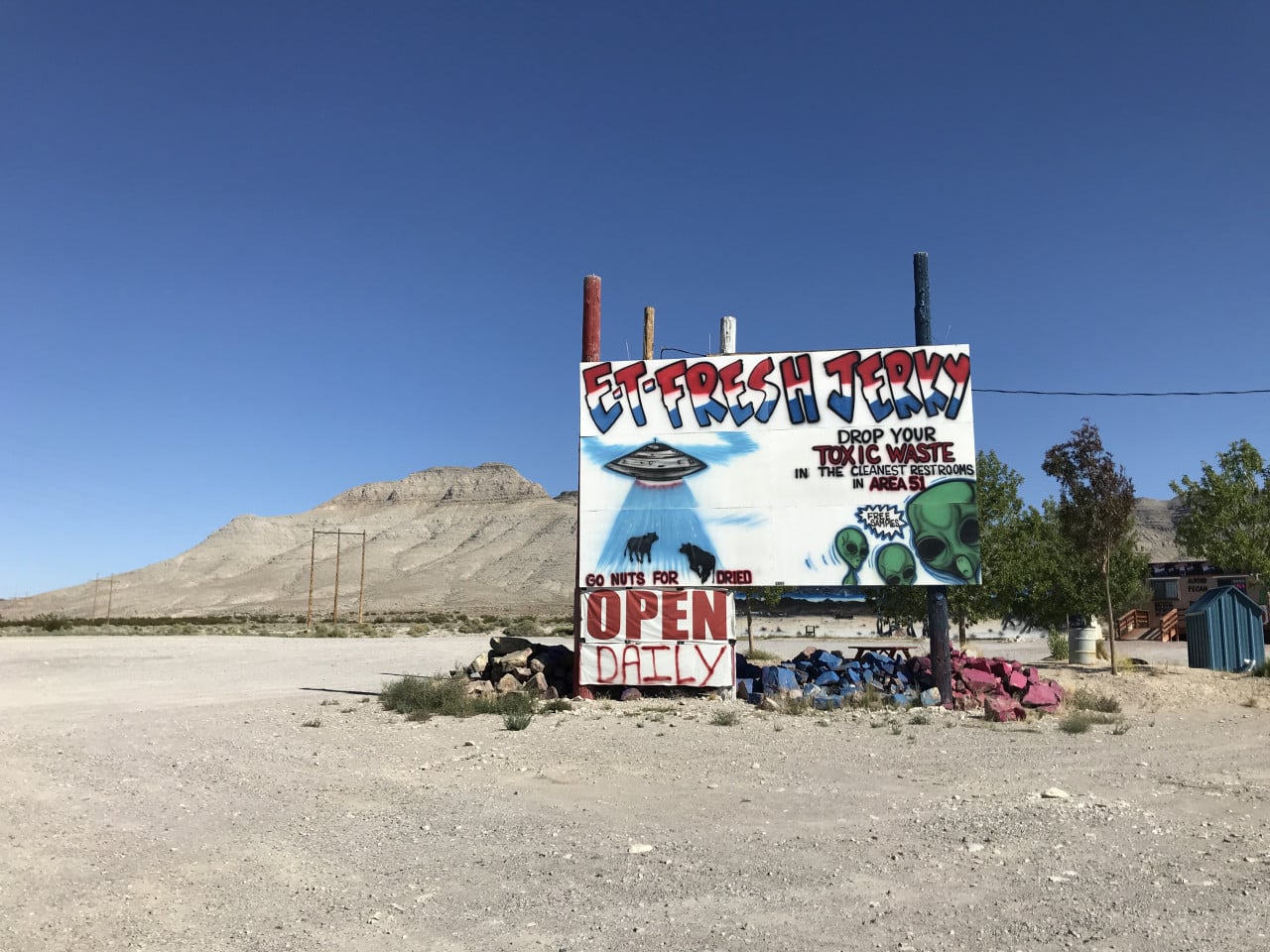 Barevný nápis ET-FRESH JERRY u pouštní cesty, hor a modré oblohy.