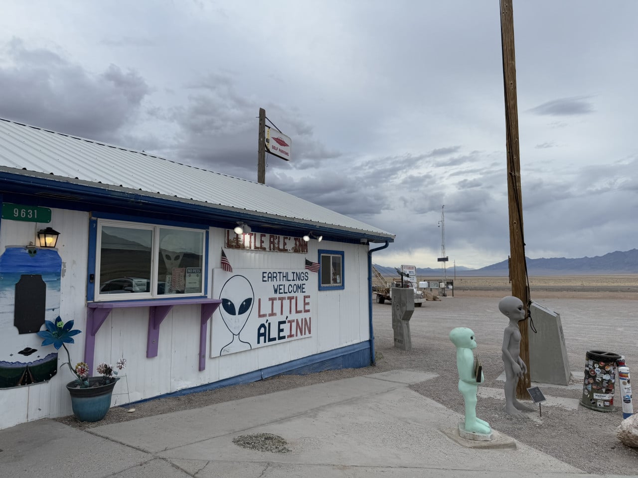 Budova Little A'Le'Inn s nápisem Earthlings Welcome a figurami mimozemšťanů v pouštní krajině