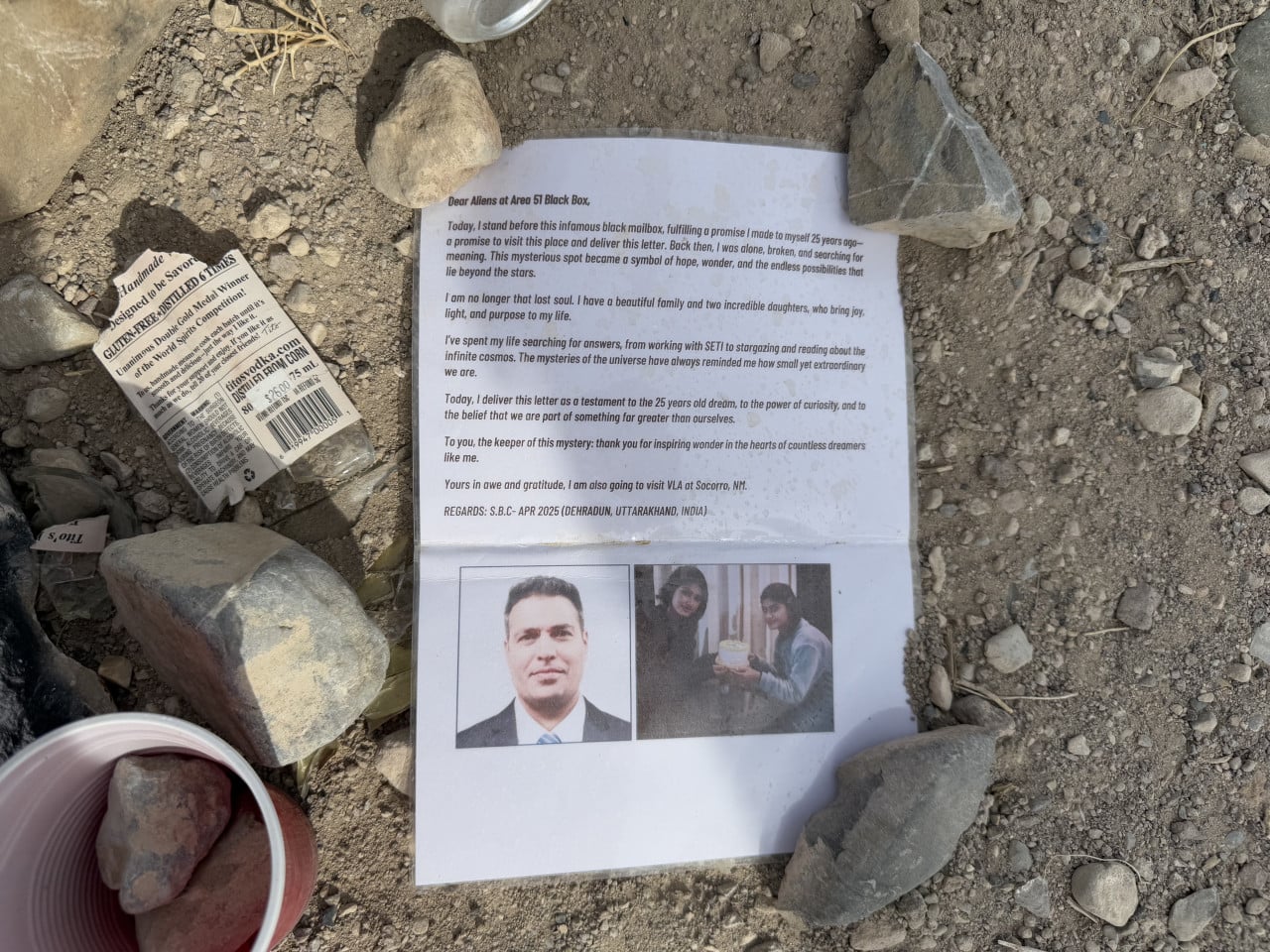 Dopis a fotografie položené na kamenité zemi v poušti u Area 51 Black Box.