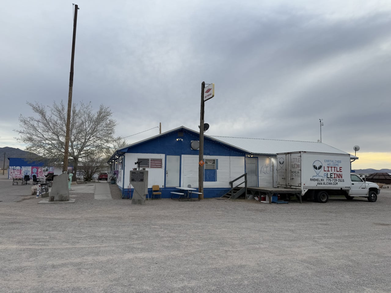 Budova v Rachel u Area 51 s nápisem Little A'Le'Inn a zaparkovanou dodávkou.