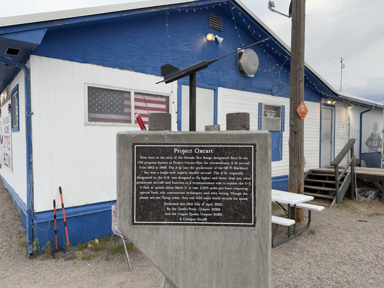 Pamětní deska Project Oxcart před modro-bílou budovou s modelem letounu a americkou vlajkou.
