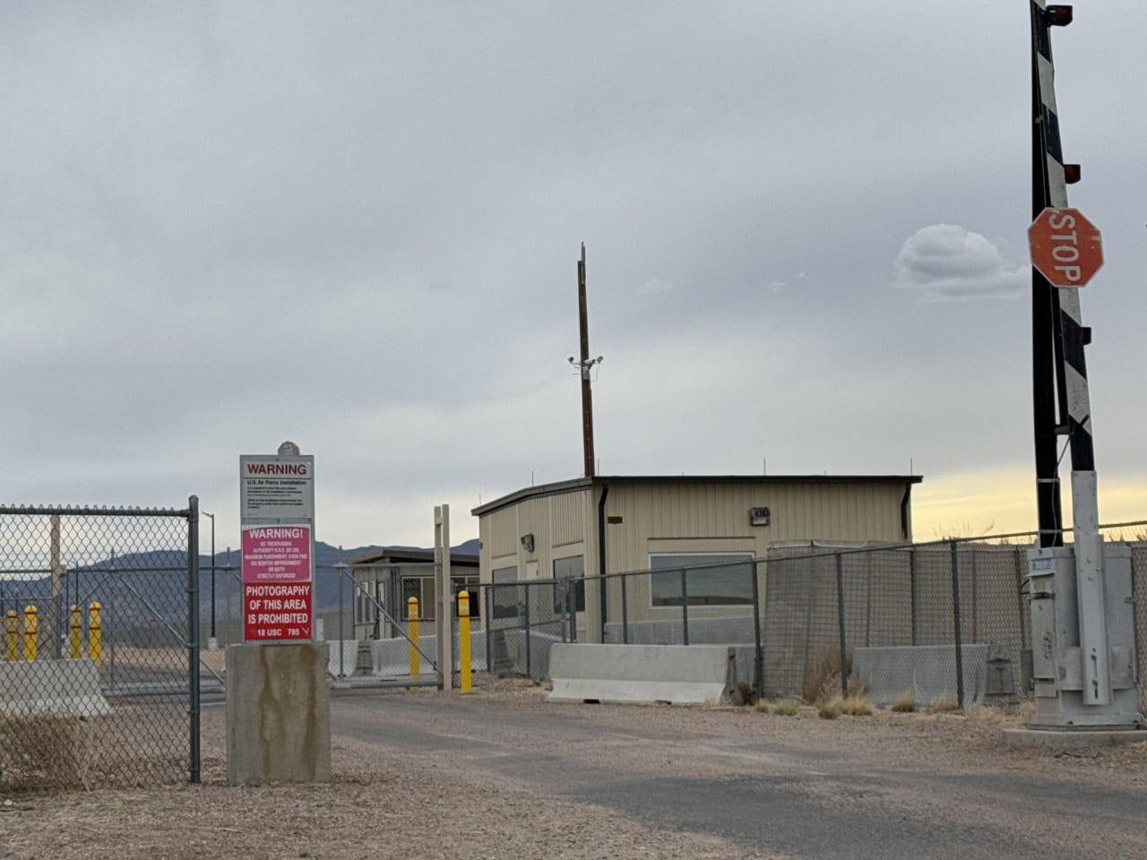 Brána Area 51 v poušti s varovnými cedulemi a stopkou.