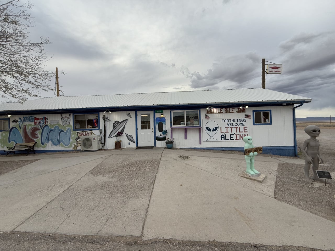 Pohled na Little A’Le’Inn v Rachel s mimozemskými sochami a nápisy Earthlings Welcome.