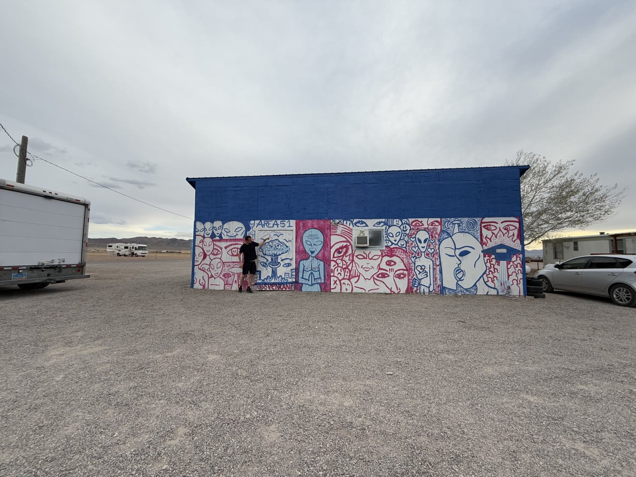 Modrá budova s barevným graffiti mimozemšťanů v pouštním městečku Rachel, Nevada.