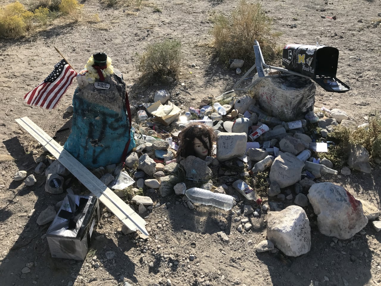 Pohřební památník z kamenů, americká vlajka a poštovní schránka v nevadské poušti