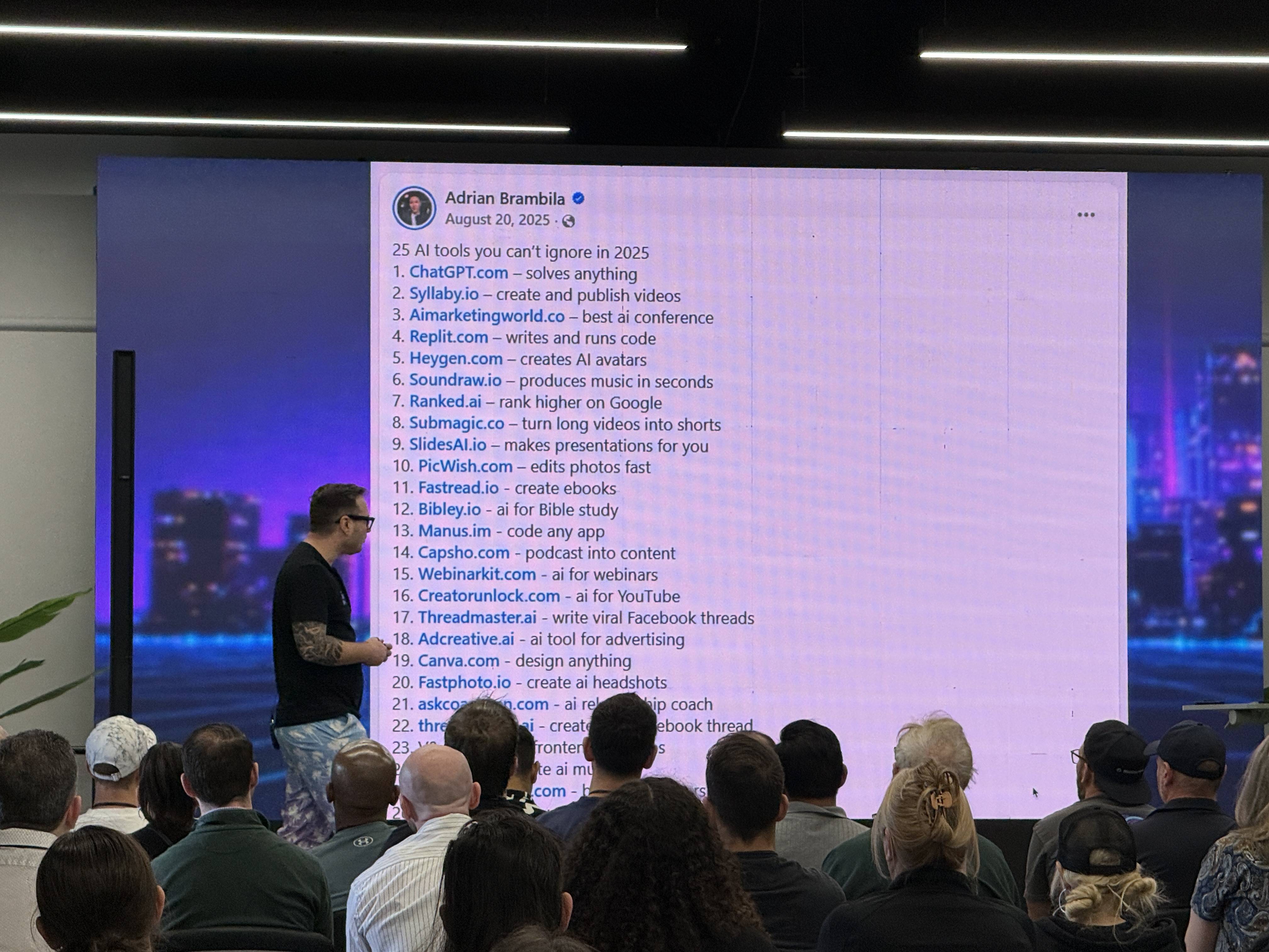 Přednášející před publikem ukazuje slide Adrian Brambila: 25 AI tools you can’t ignore in 2025.