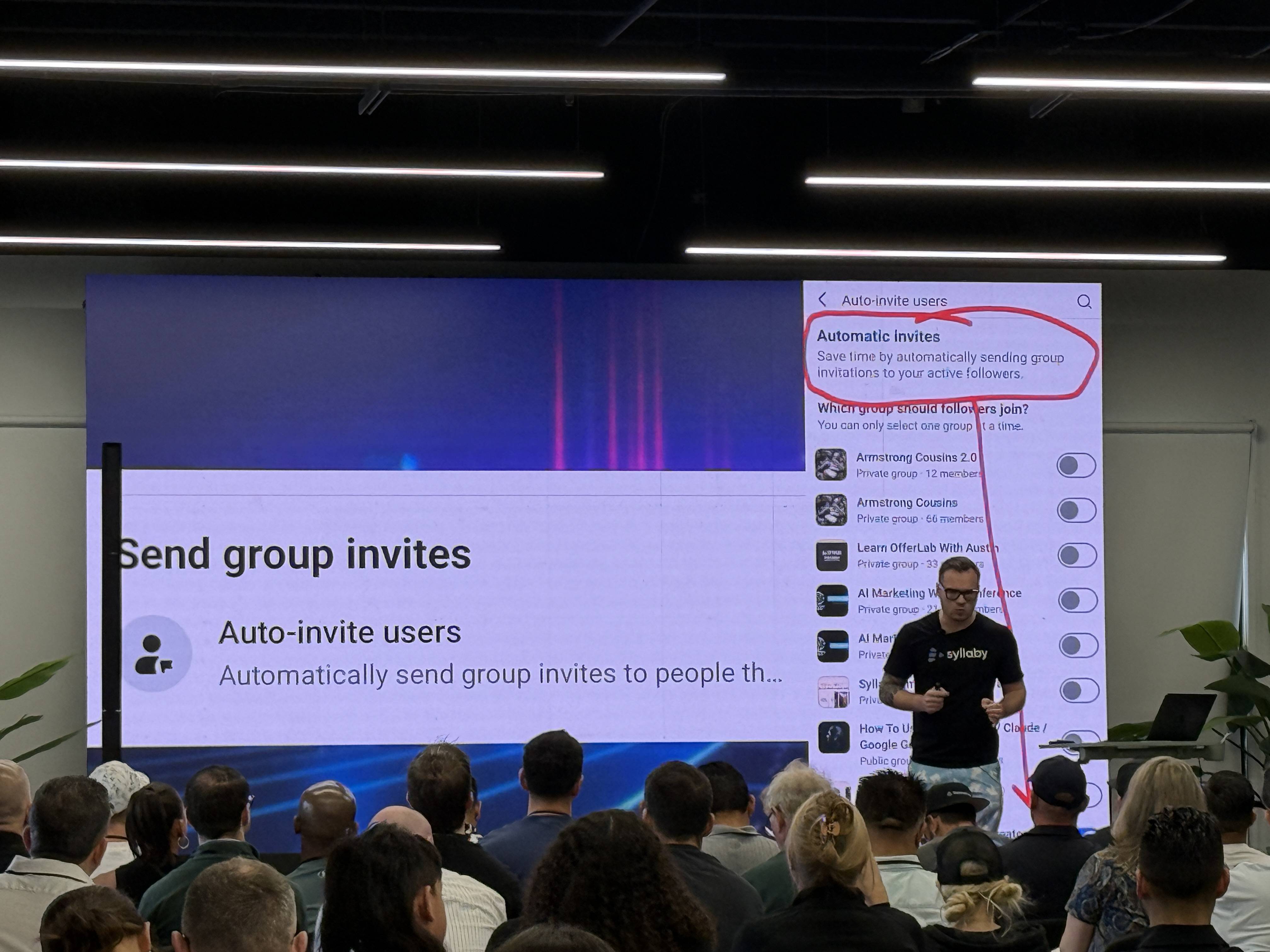 Přednášející před publikem, na plátně text Send group invites a Auto-invite users.