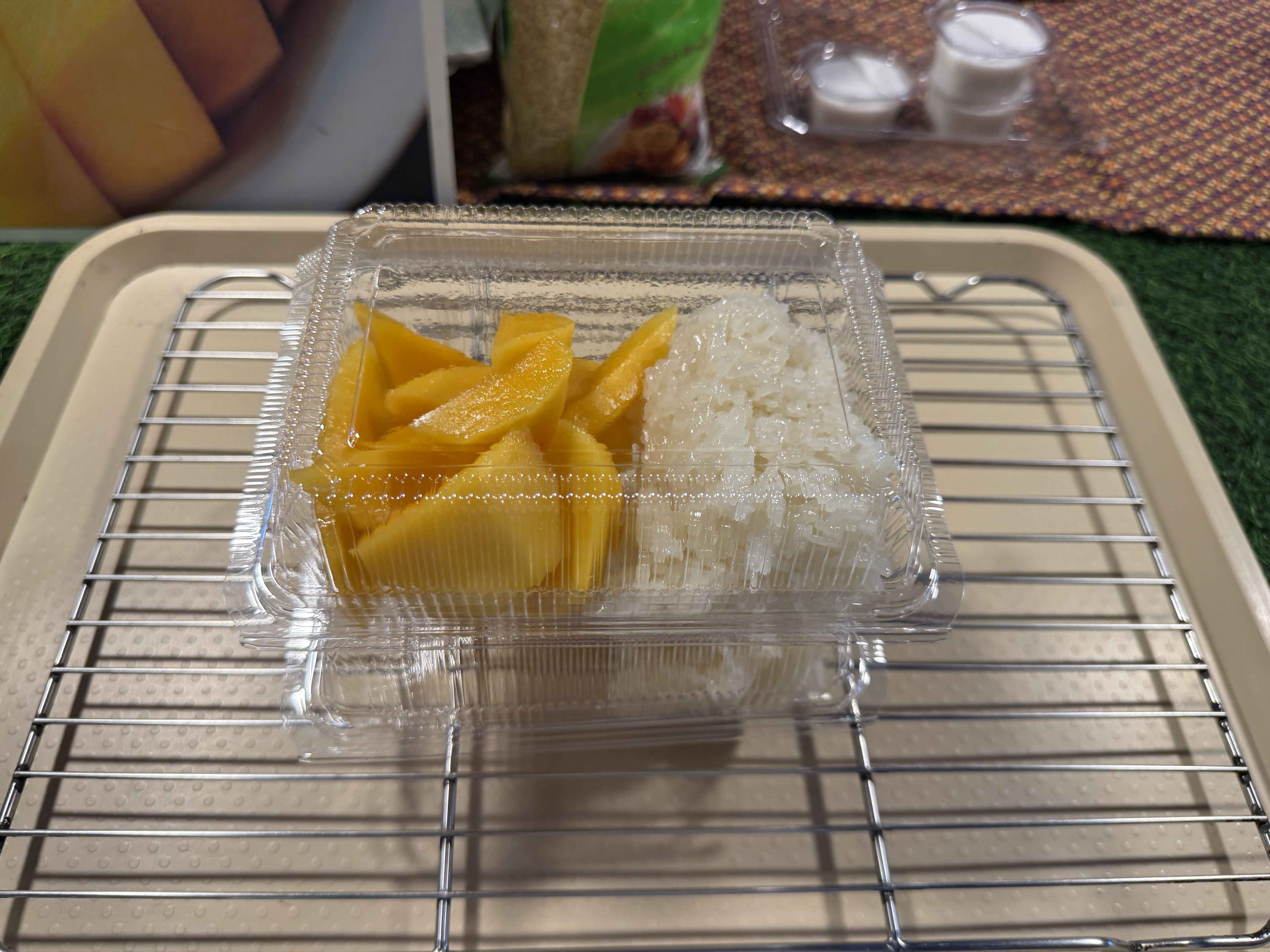 Plastový box s mangem a lepkavou rýží na kovové mřížce