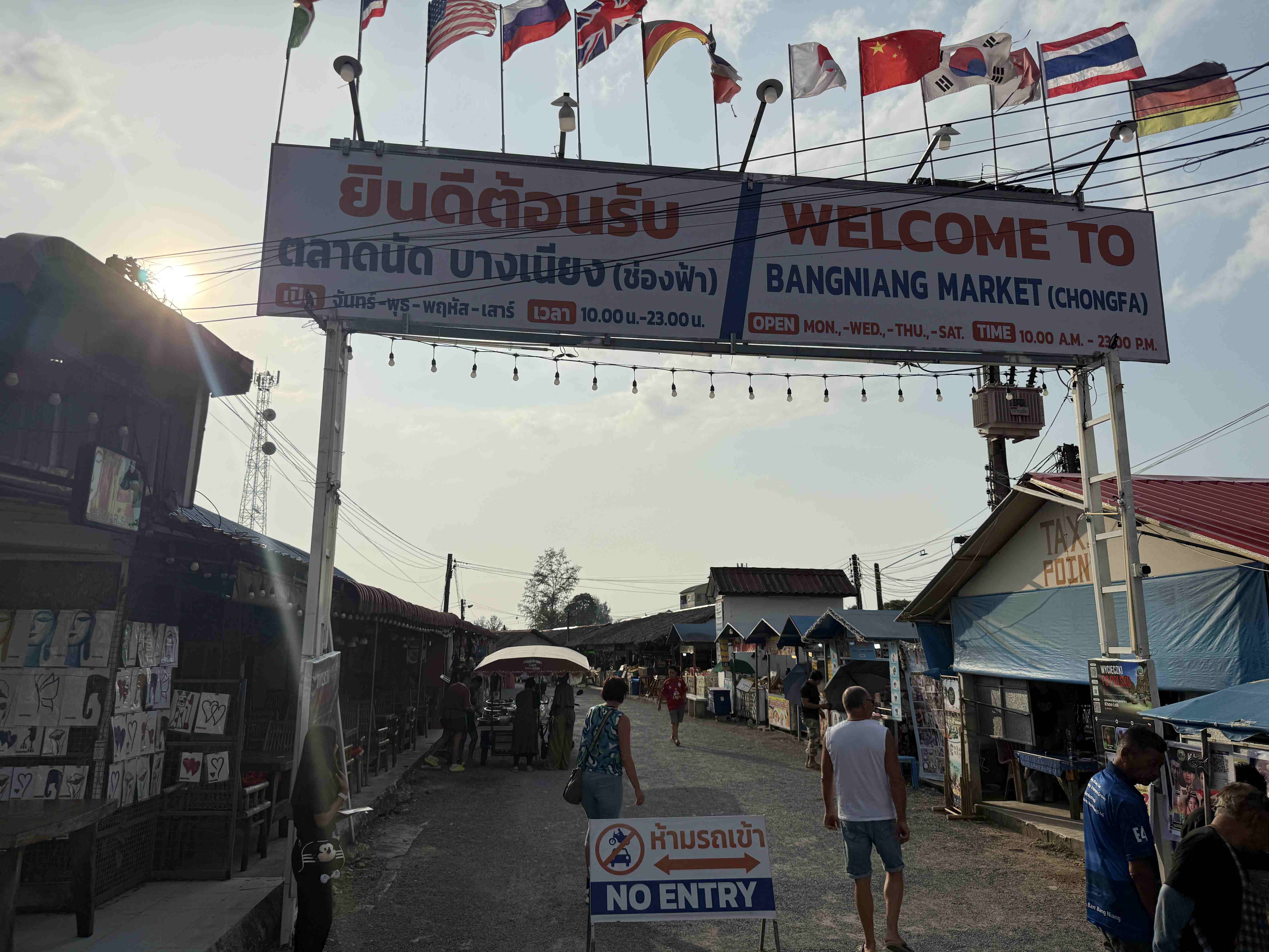 Vstupní brána s nápisem WELCOME TO BANGNIANG MARKET, vlajky a cedule NO ENTRY