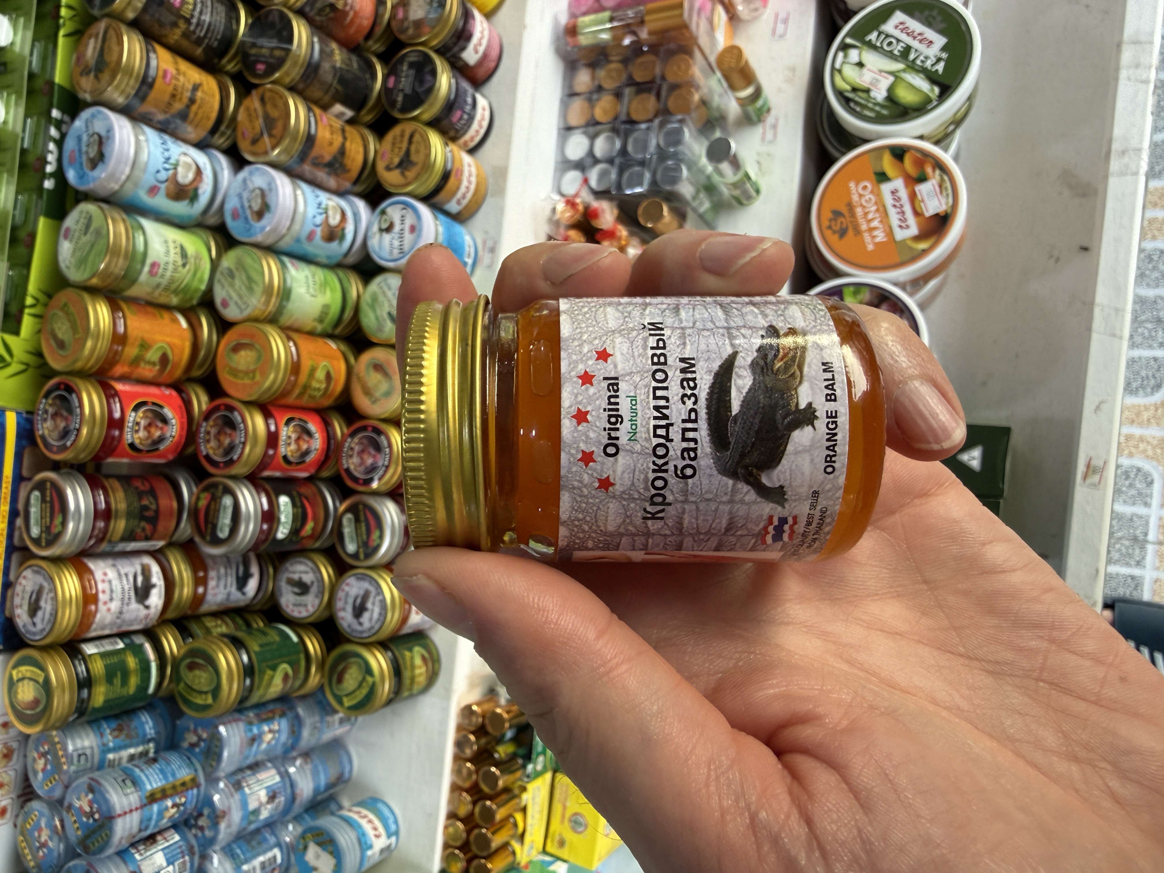 Ruka drží skleničku Original Natural Крокодиловый бальзам ORANGE BALM na trhu