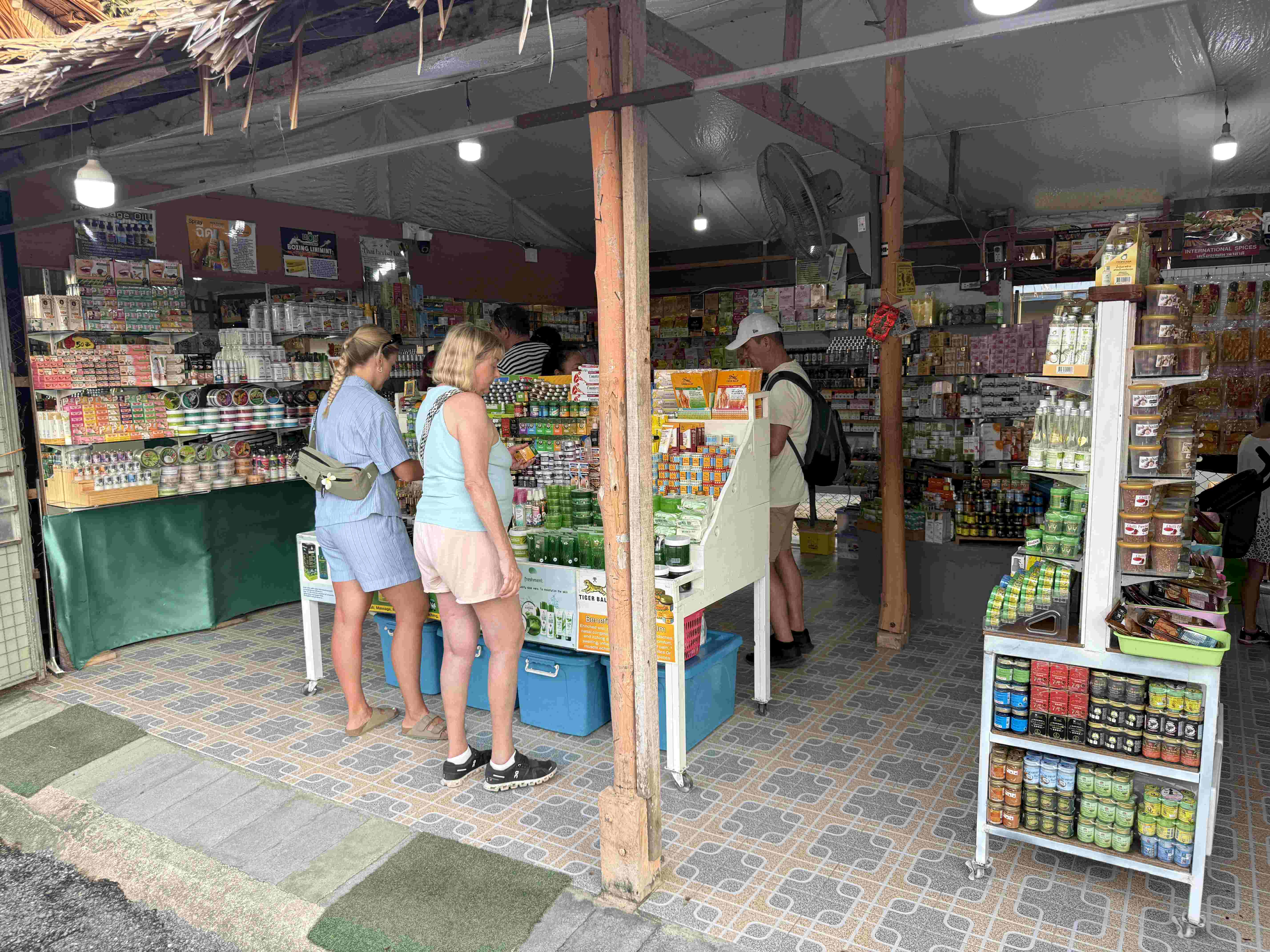 Turisté vybírají thajské mastičky a oleje v krámku na Bang Niang Marketu.
