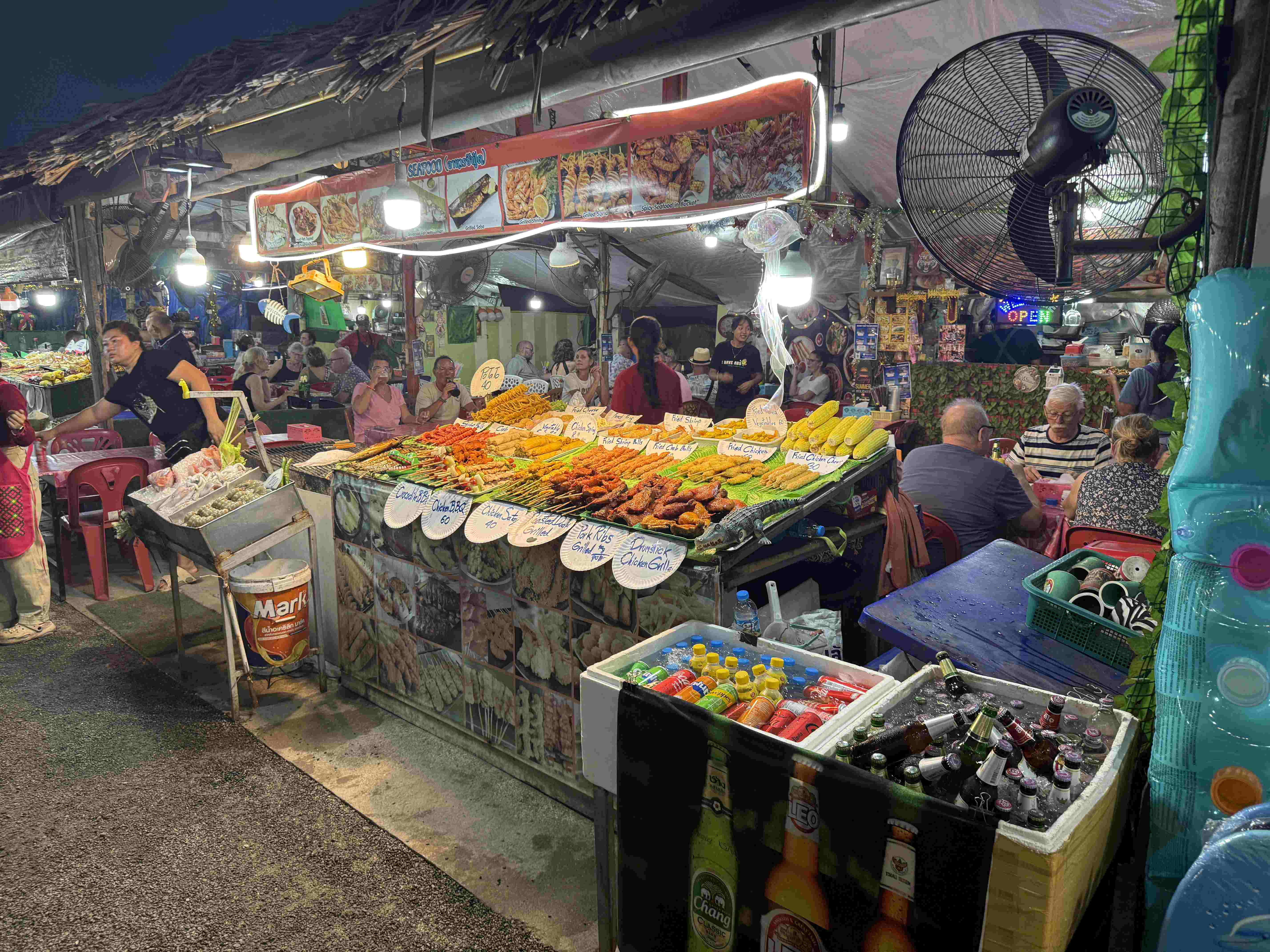 Stánek s grilovanými špízy, cedule BBQ 40 a Fried Chicken, Bang Niang Market.