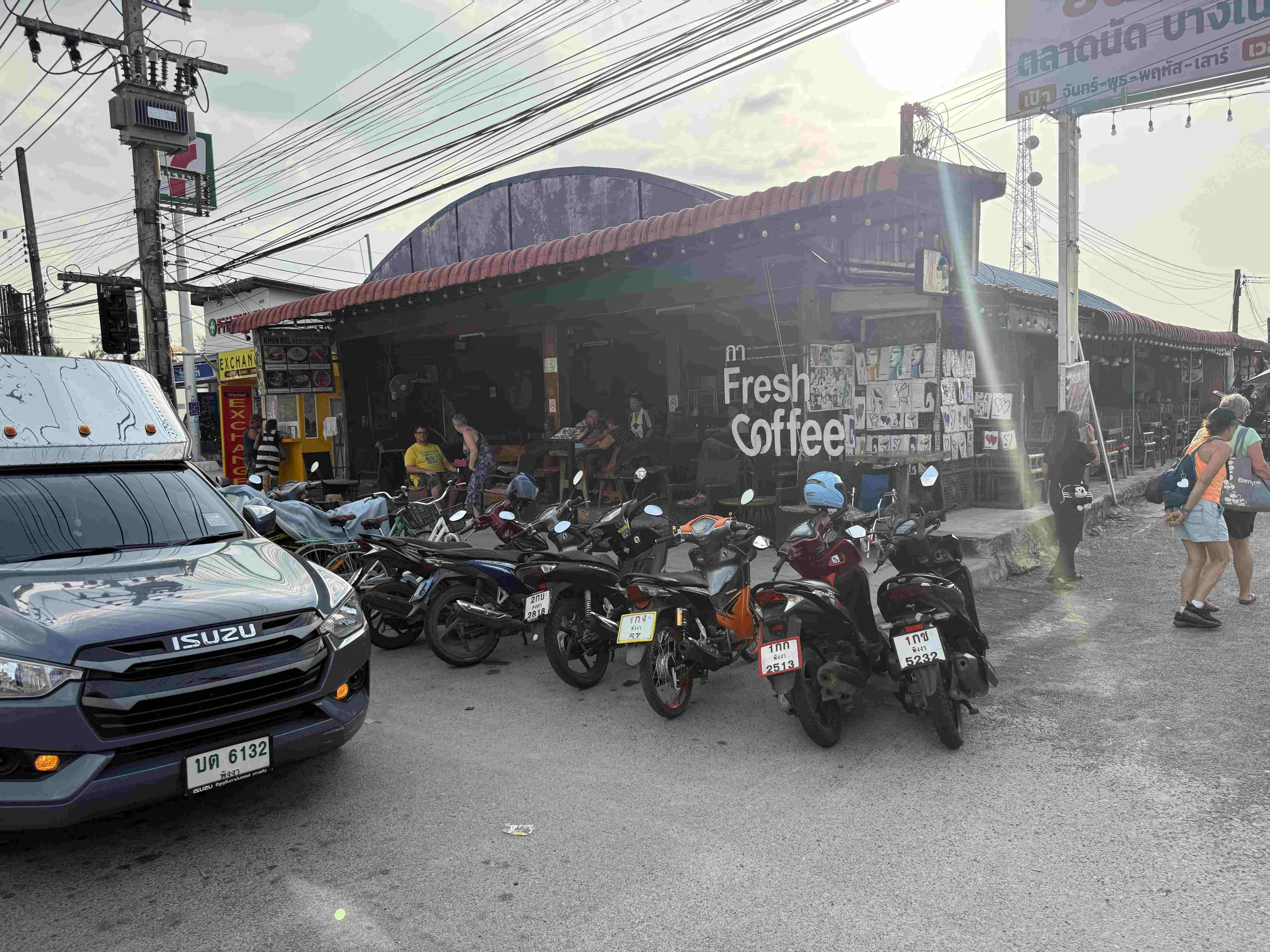 Zaparkované skútry před stánkem s nápisem Fresh coffee! u Bang Niang Marketu