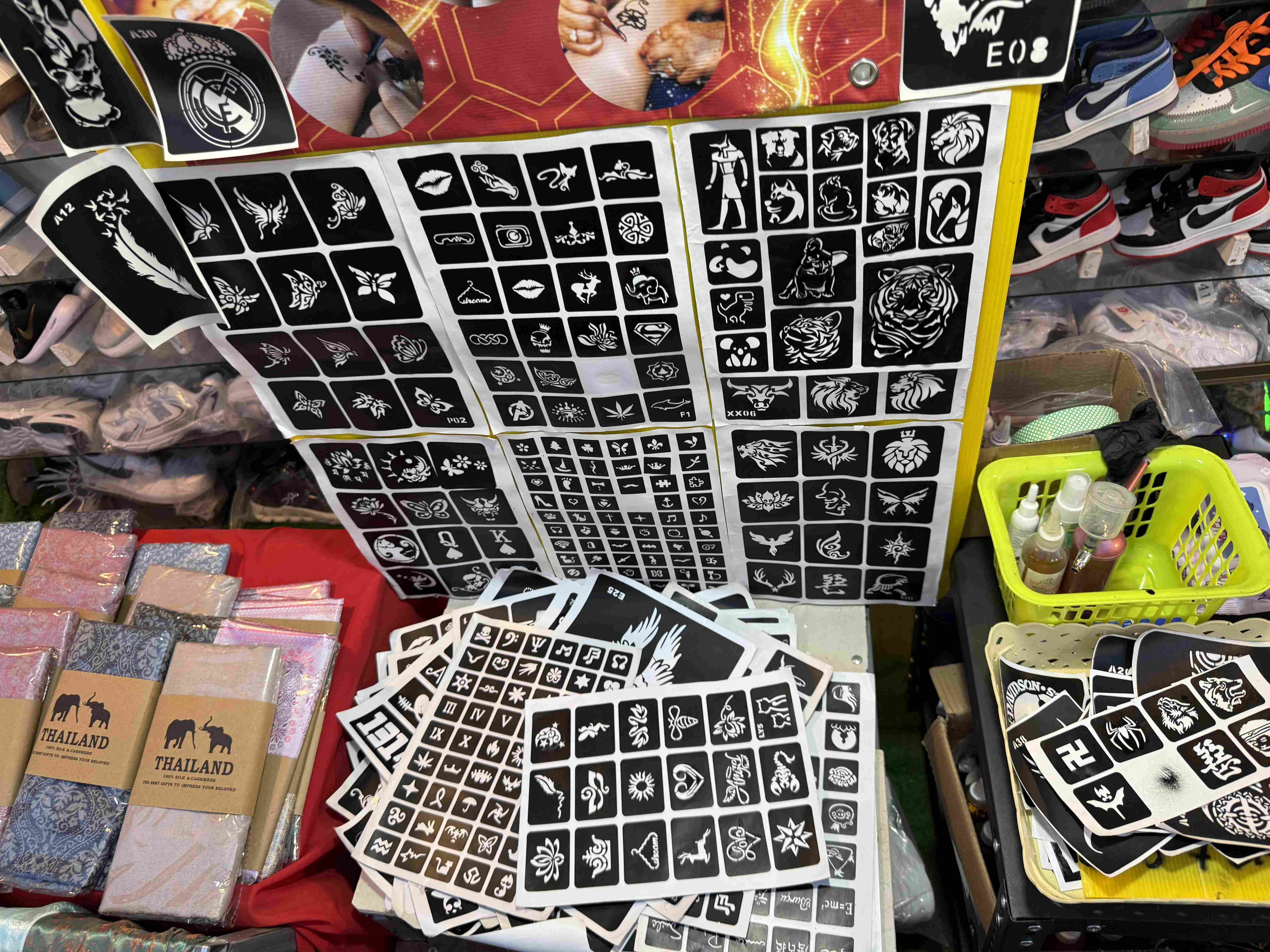 Šablony na dočasné tetování na trhu, vedle balíčků s nápisem THAILAND