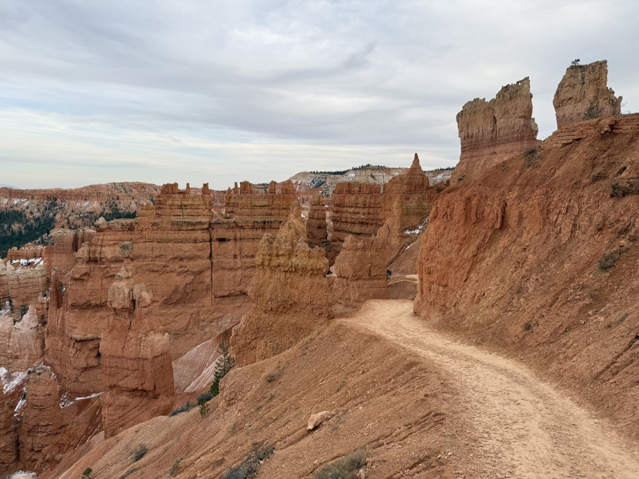 Pěšina na okraji Bryce Canyonu mezi červenými skalními věžemi a útesy