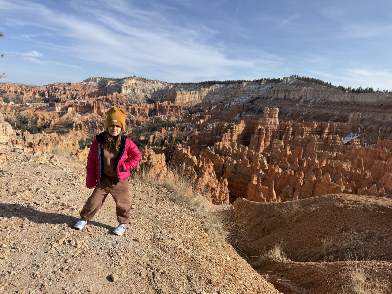 Dítě v růžové bundě a žluté čepici na vyhlídce Bryce Canyonu