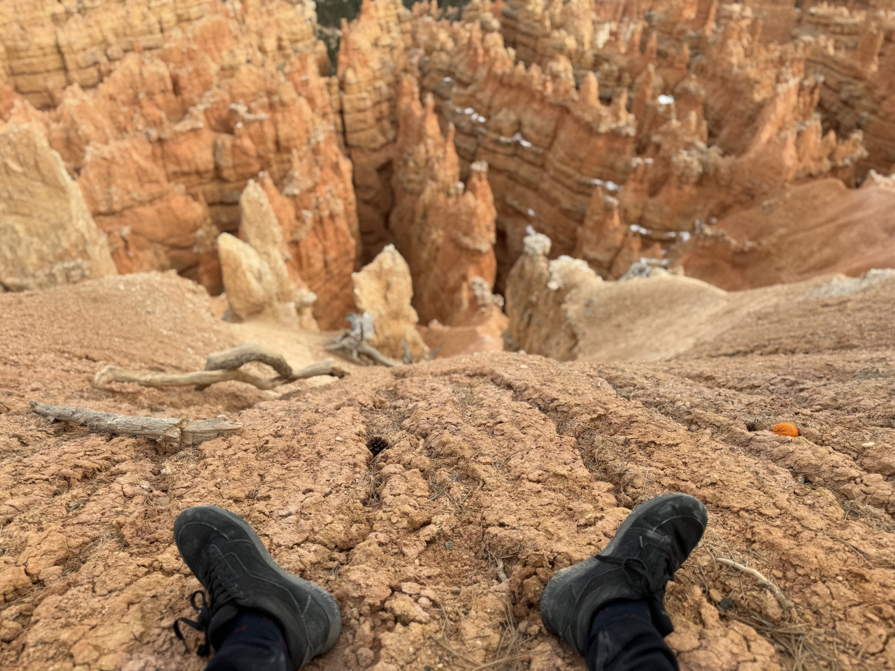 Černé boty na okraji skály, výhled na oranžové skalní věže Bryce Canyonu