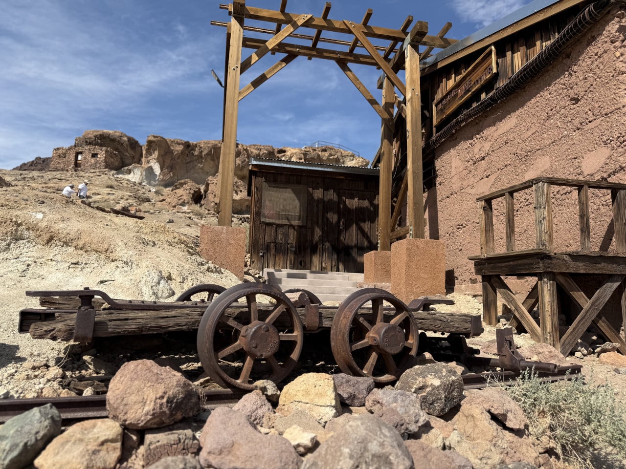 Rustikální dřevěný vozík s kolejemi u staré budovy v Calico Ghost Town.