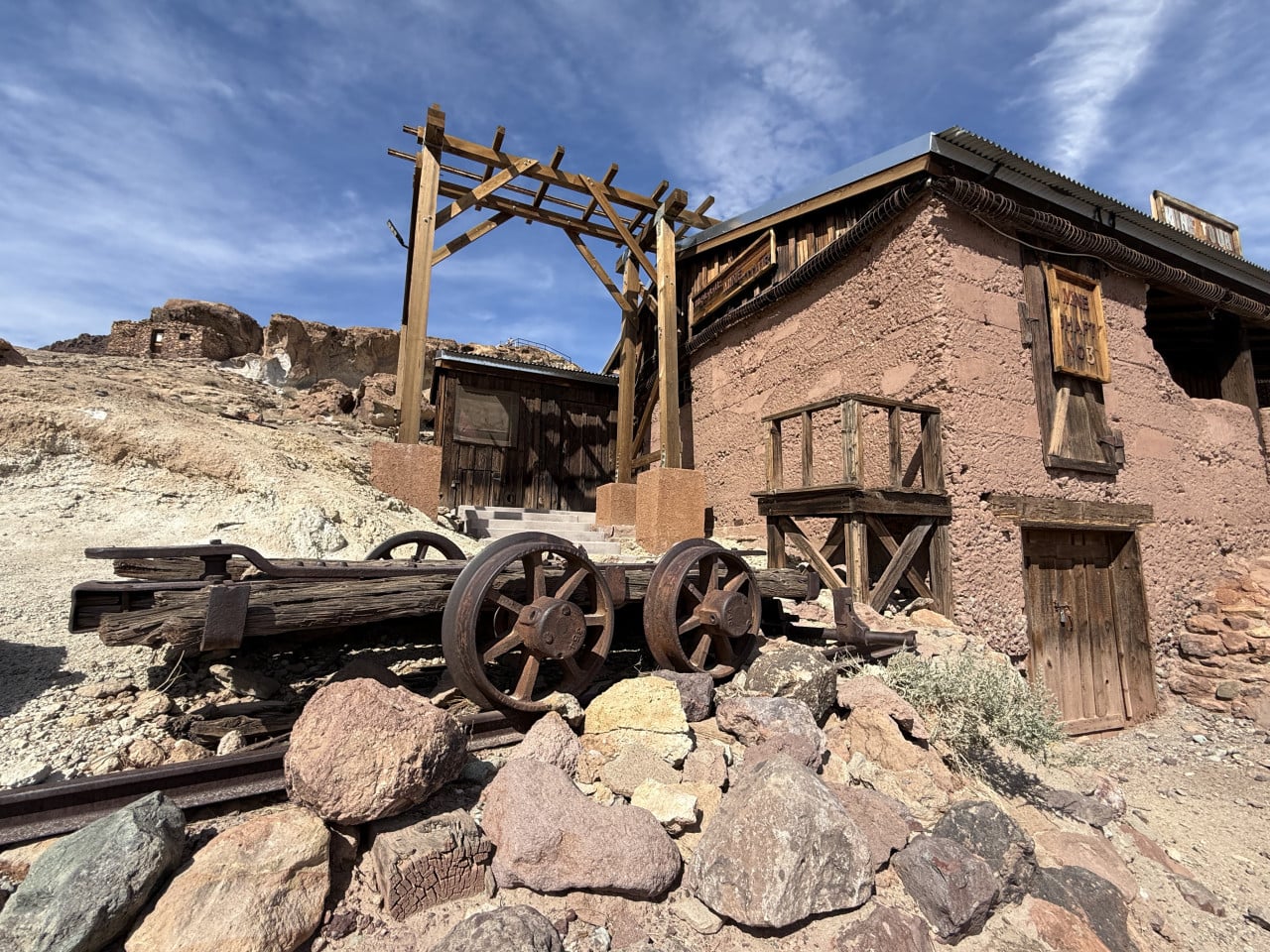 Dřevěný důlní objekt s vozíkem a nápisem Mine Shaft No. 13 v poušti.