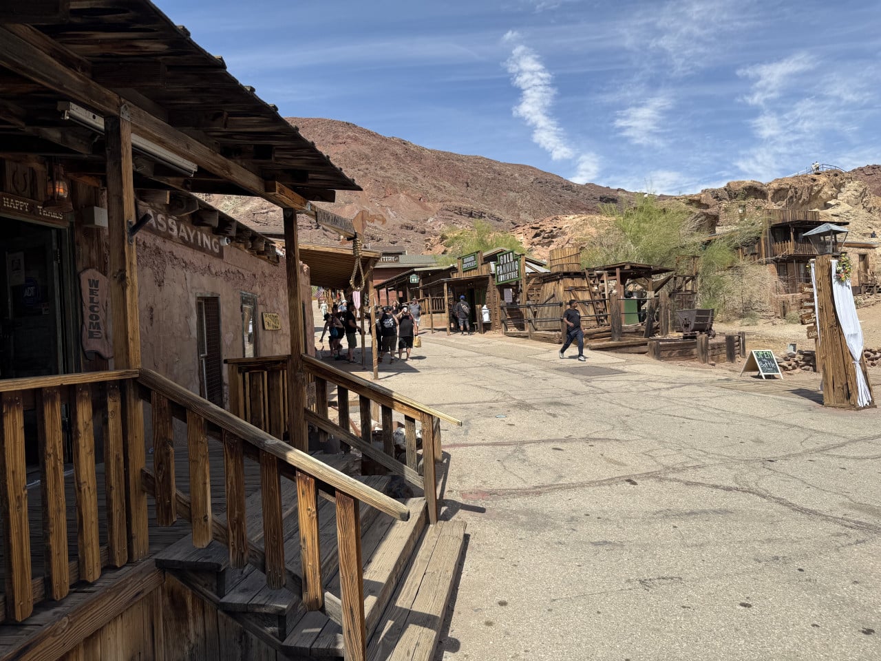 Dřevěné budovy v pouštním městečku Calico Ghost Town s turisty na ulici.