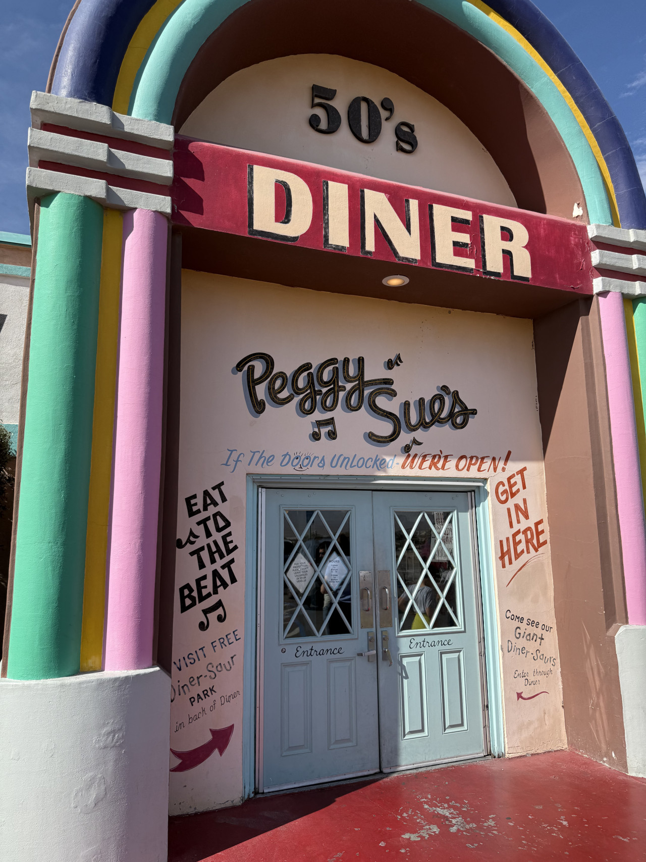 Barevný retro vchod do dineru Peggy Sue’s s nápisem 50’s Diner.