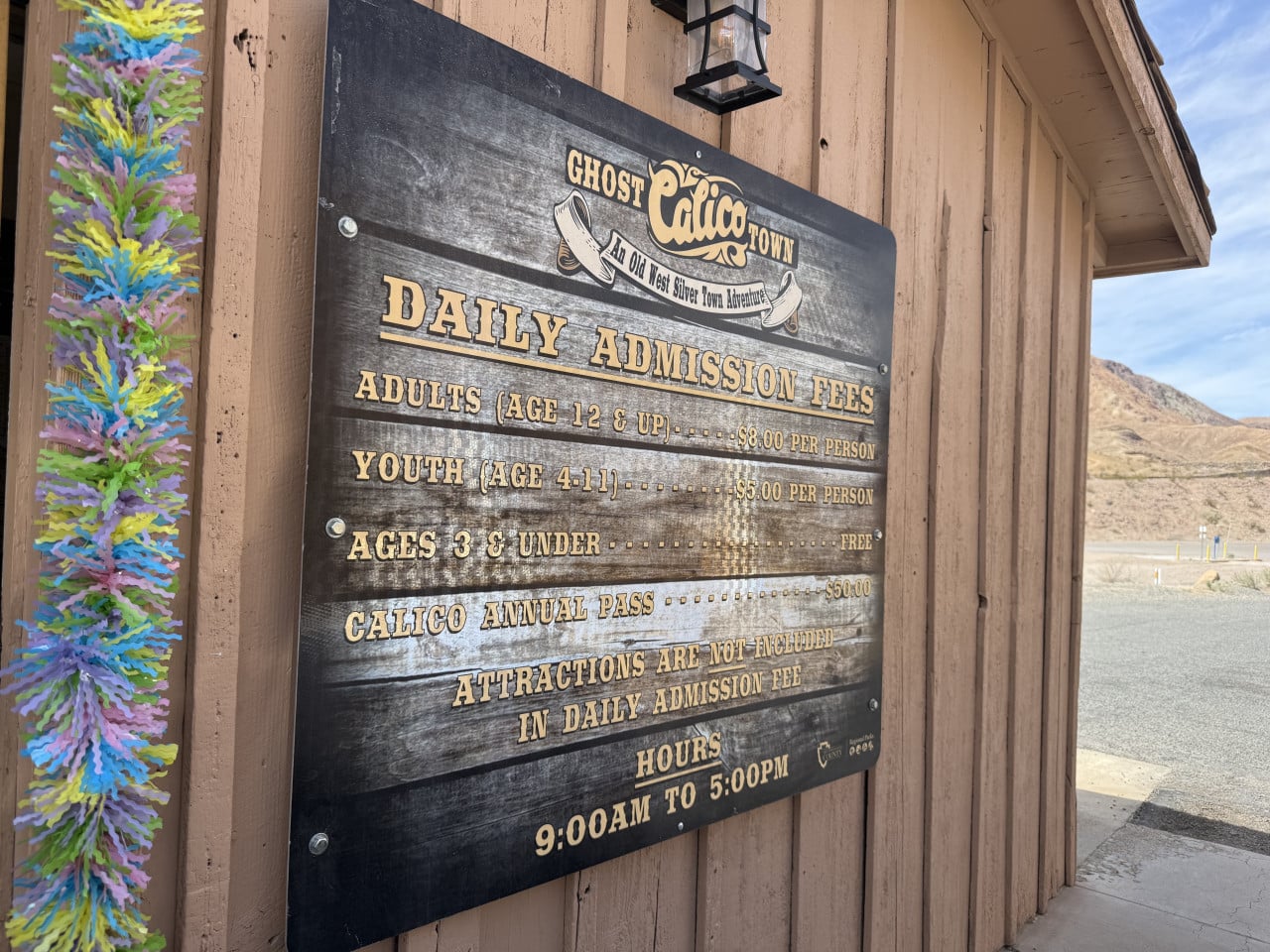 Cedule vstupu do Calico Ghost Town u dřevěné budovy v poušti.