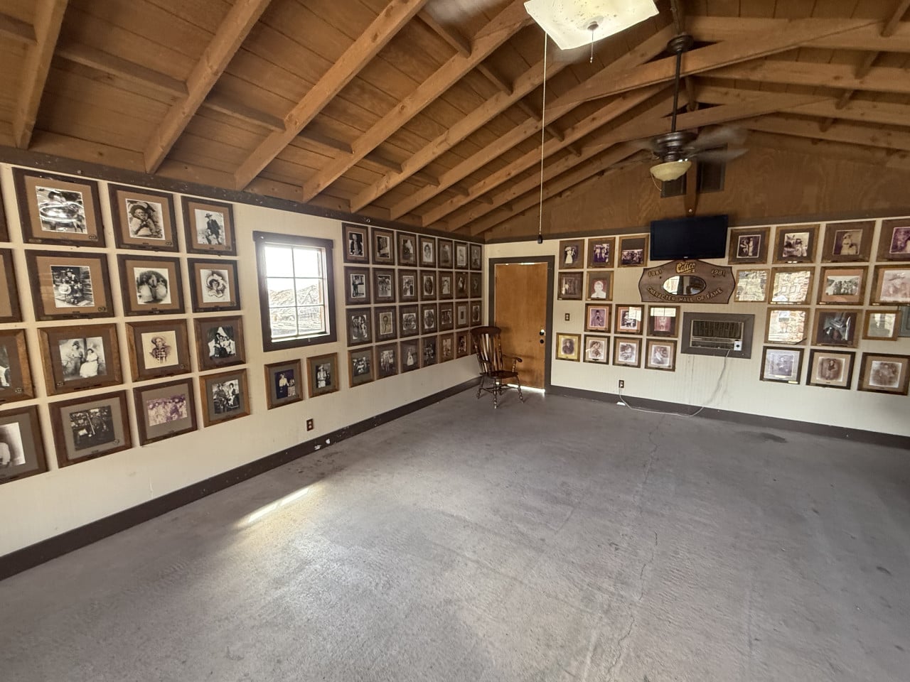 Prázdná místnost s dřevěným stropem a stěnami plnými starých fotografií Calico Ghost Town.