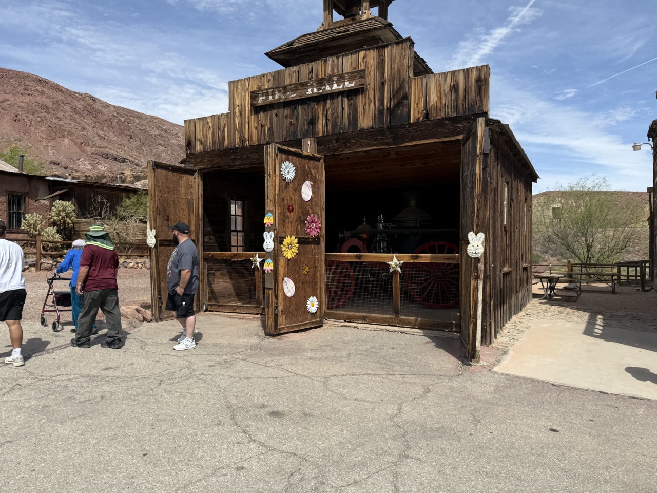 Dřevěná budova Fire Hall v pouštním městečku Calico Ghost Town, lidé stojí před ní.