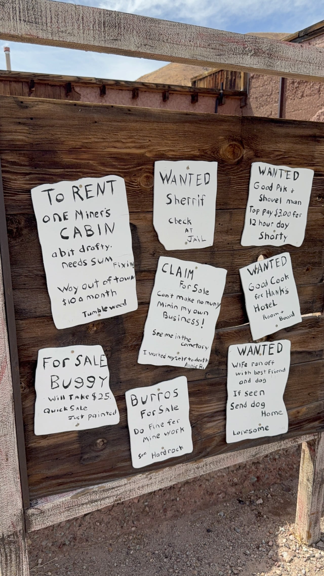 Dřevěná cedule s ručně psanými westernovými inzeráty v Calico Ghost Town.