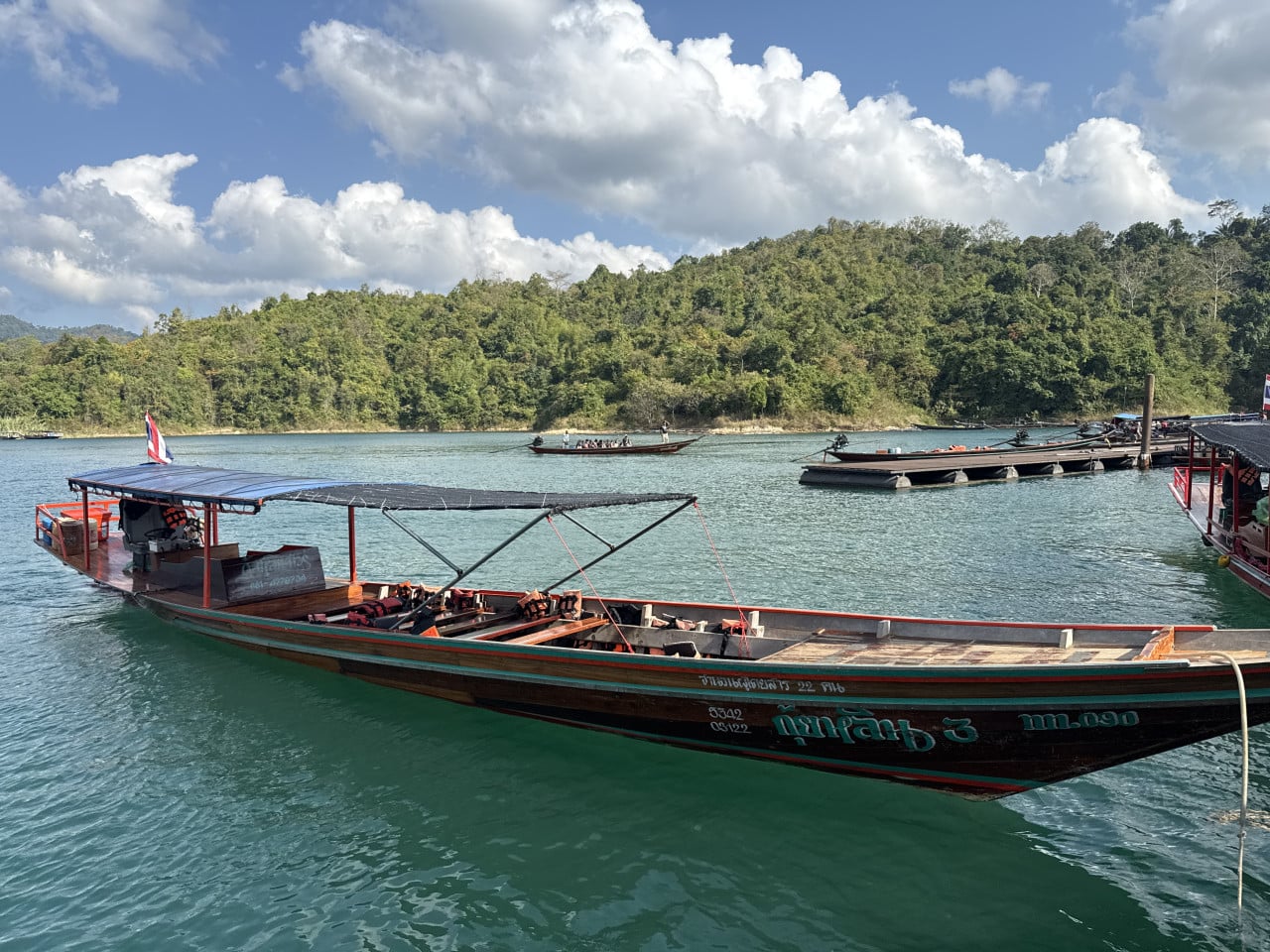 Dřevěná loď na jezeře Cheow Lan, nápis เกาะลาน 3, džungle v pozadí