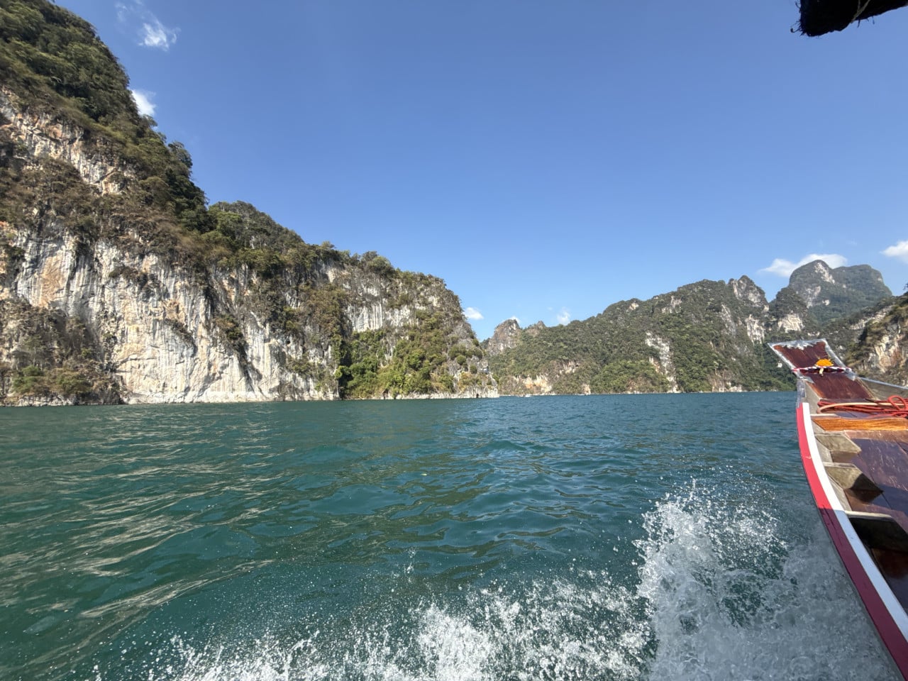 Pohled z longtail člunu na smaragdové jezero a vápencové skály, Khao Sok.