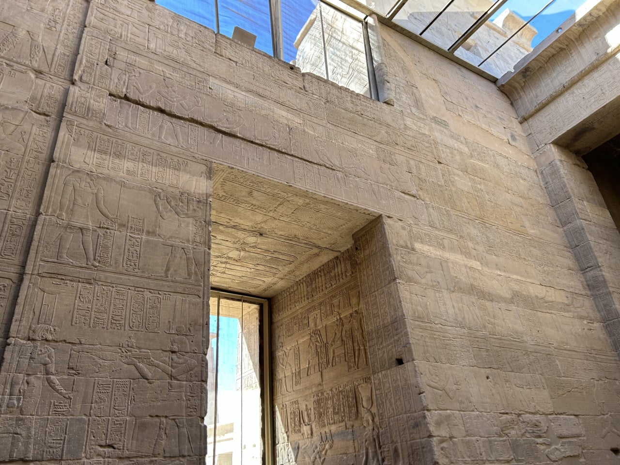 Vytesané hieroglyfy na pískovcových zdech chrámu Philae, pohled na vstupní portál.