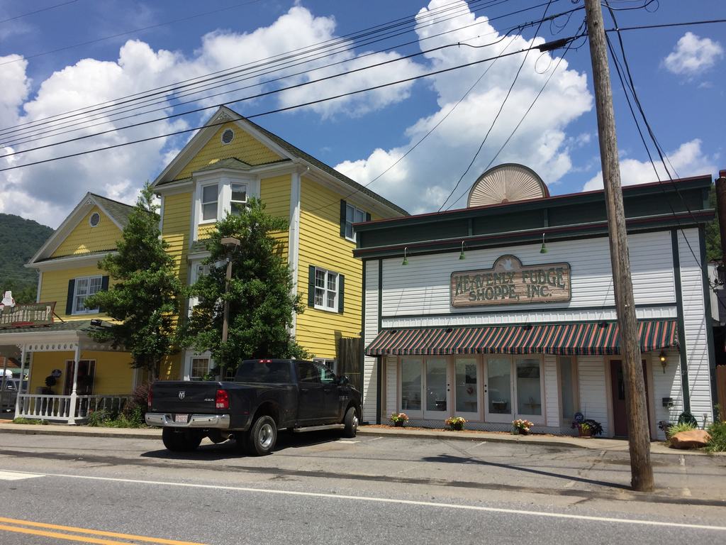 Ulice s černým pickupem před budovou s nápisem GENERAL STORE SHOPPING, INC.