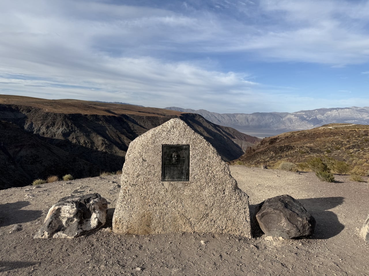 Pamětní kámen v Death Valley s výhledem na horské hřebeny a poušť