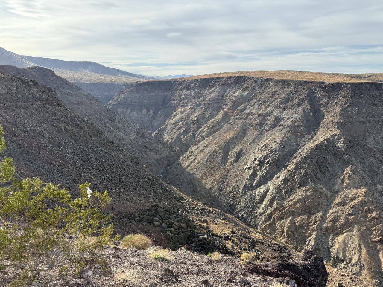 Strmé skalnaté údolí v Death Valley pod zataženou oblohou