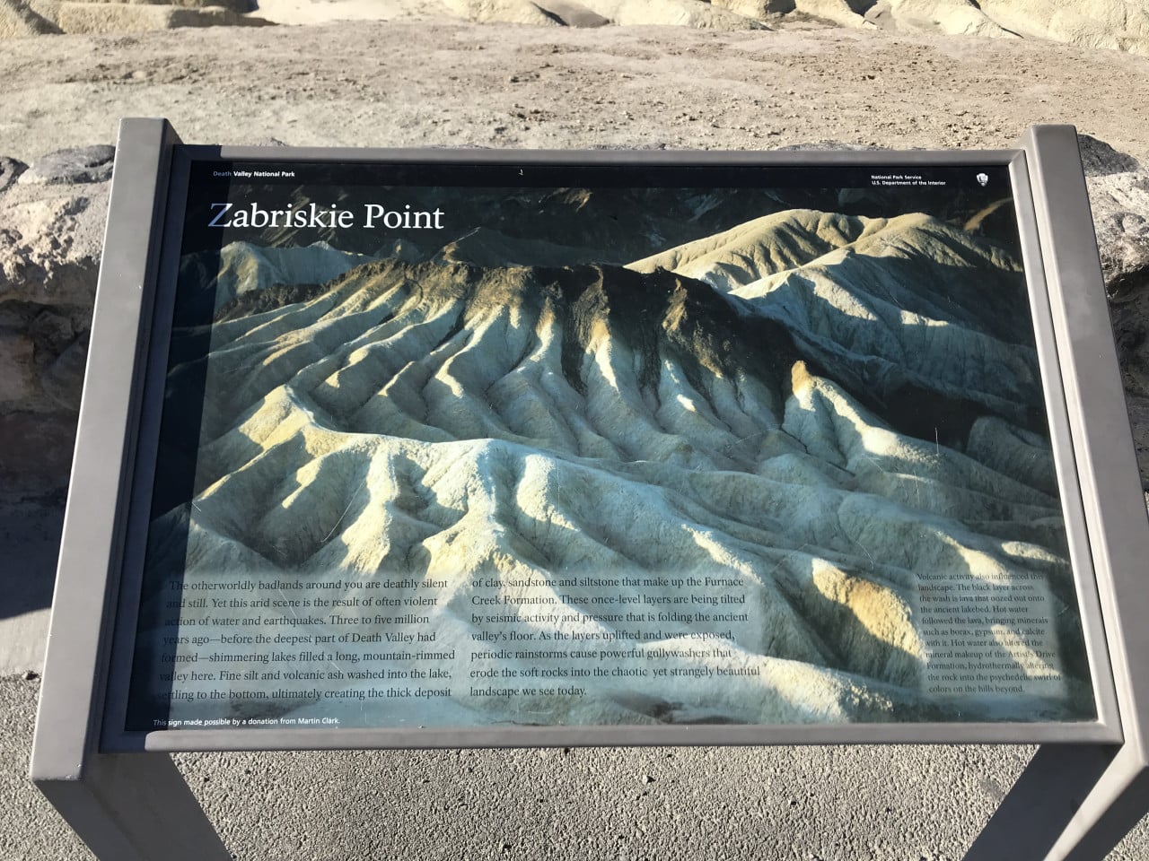 Informační panel Zabriskie Point v Death Valley s fotografií horských hřebenů