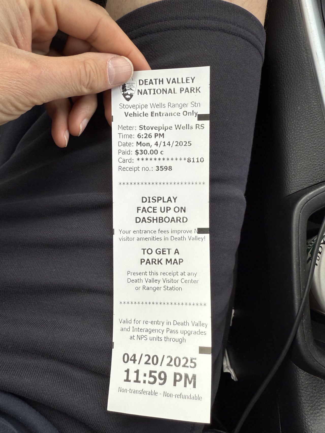 Ruka drží vstupenku do Death Valley National Park s textem a datem.